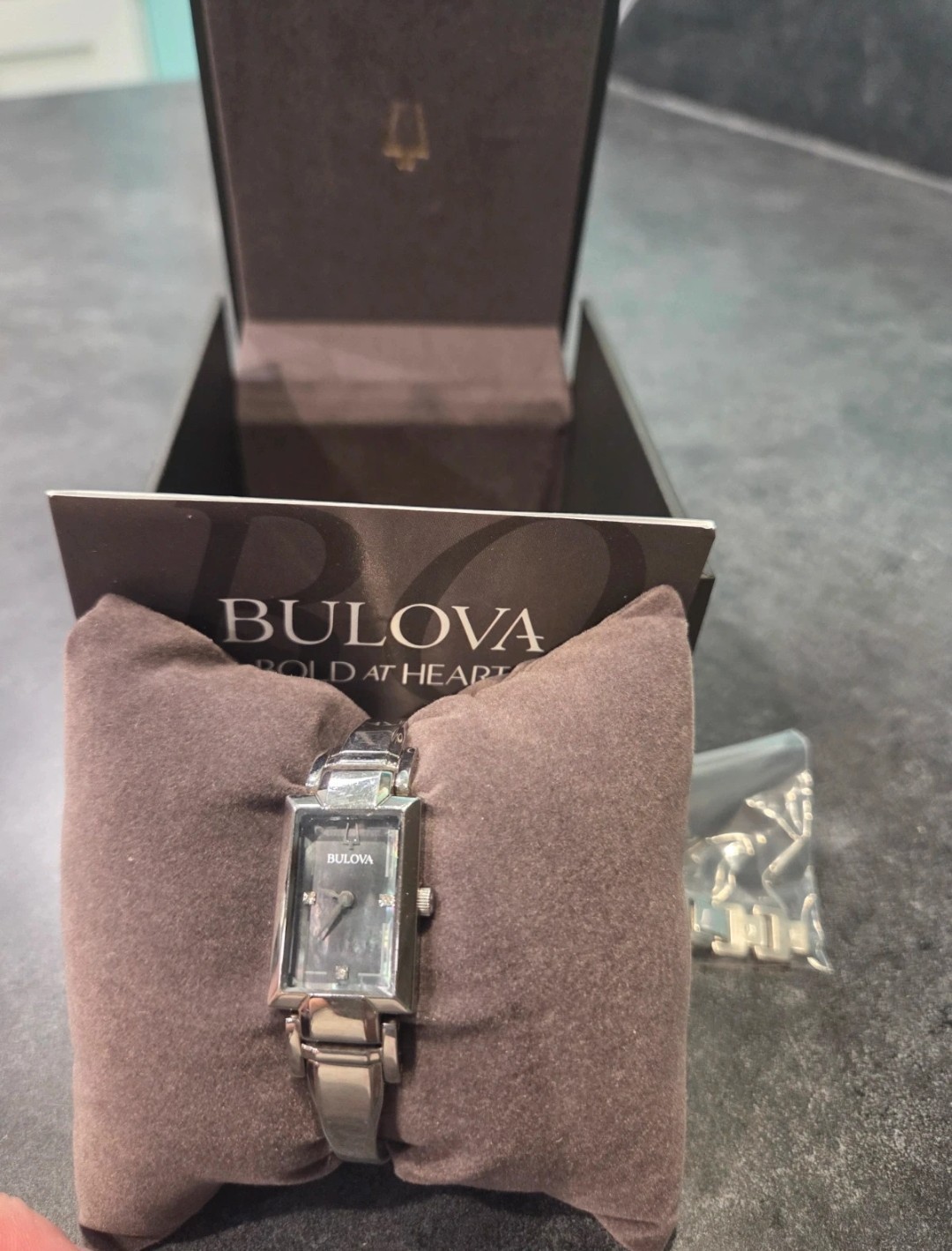 Bulova silver watch with rectangular face and diamond accents