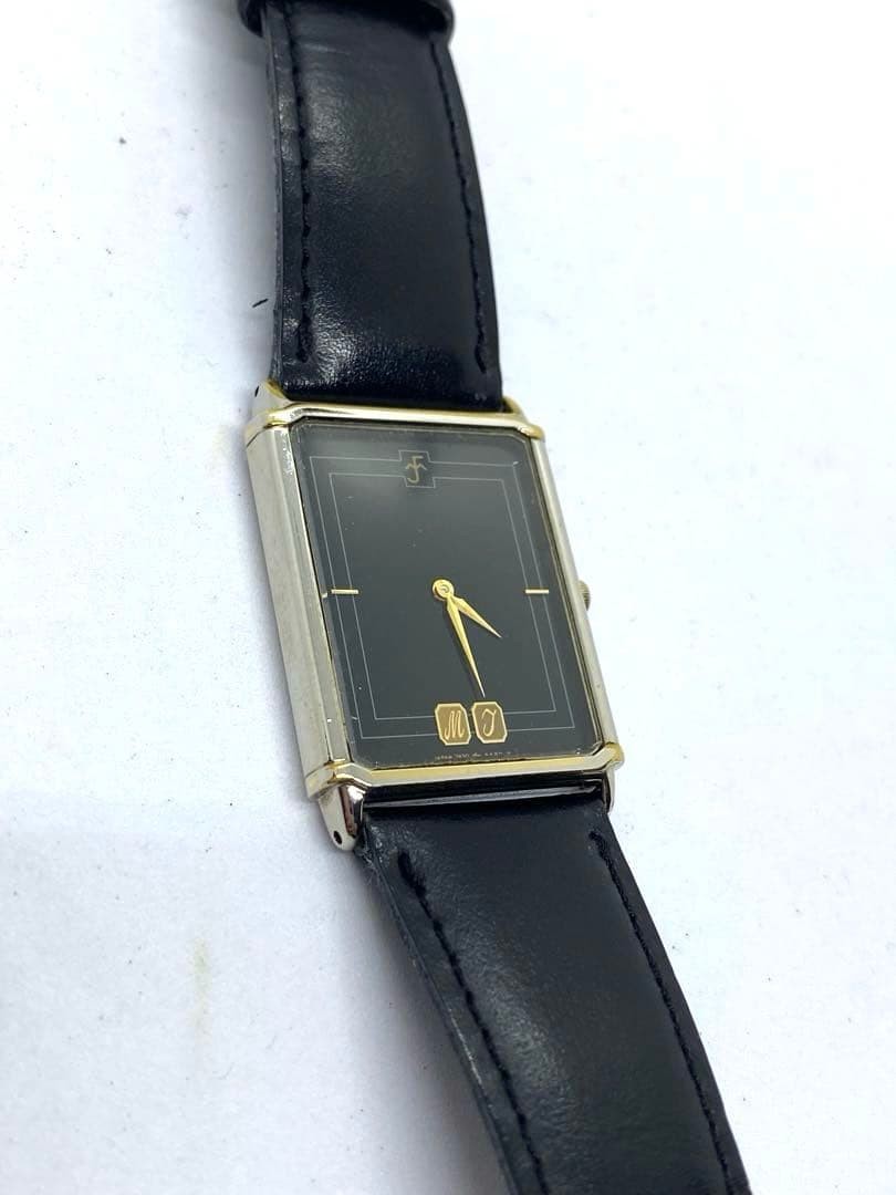 SEIKO rectangular quartz watch with black leather strap.
