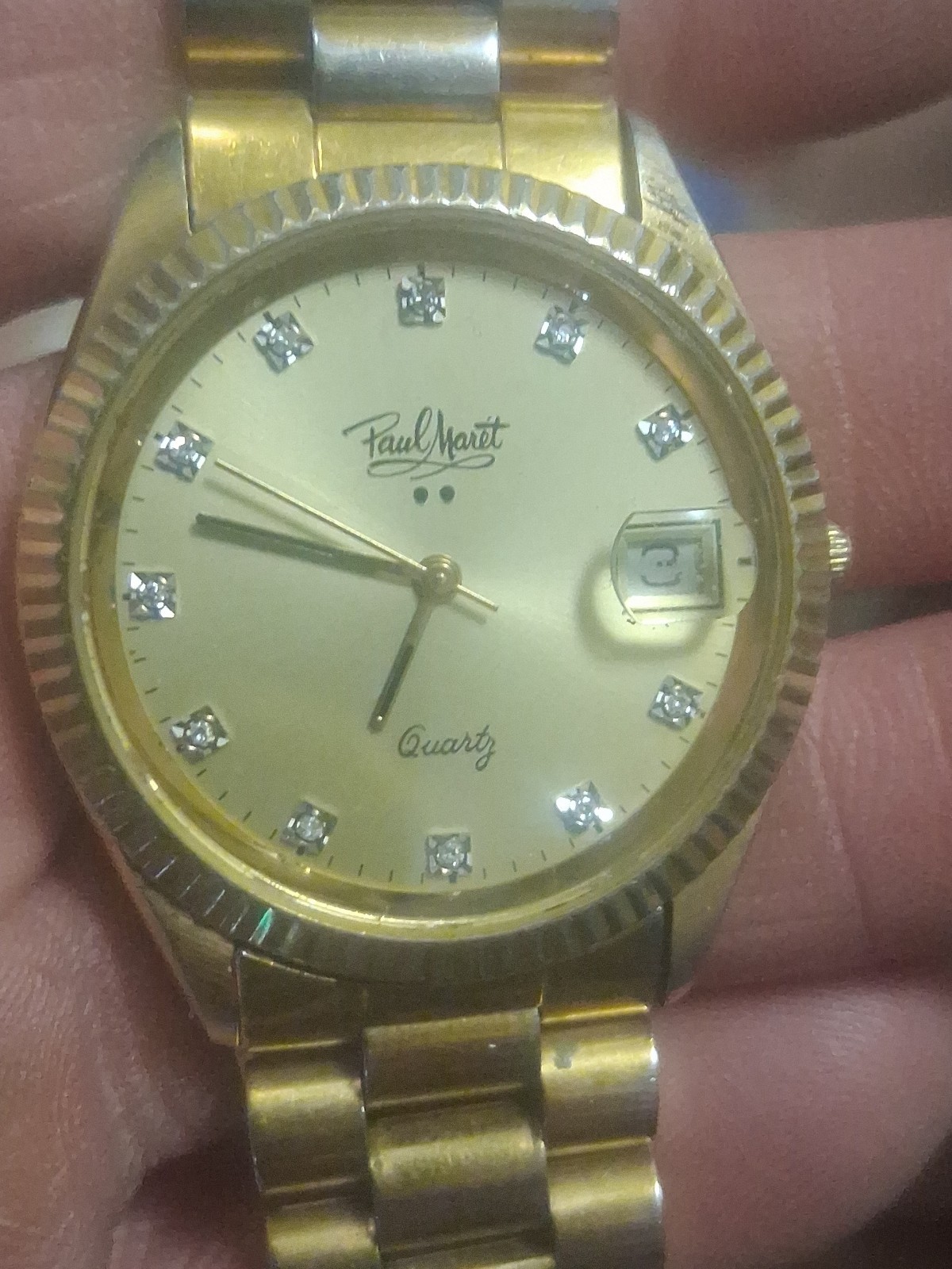 Paul Maret Quartz watch with gold-tone finish, fluted bezel, diamond markers.