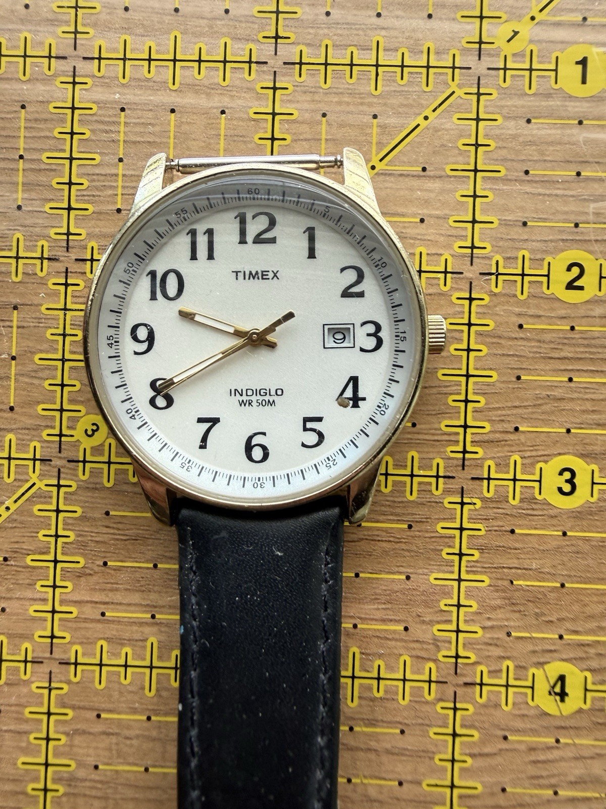 Timex Indiglo Quartz White Dial Arabic Date Gold Tone Case Black Leather 50m