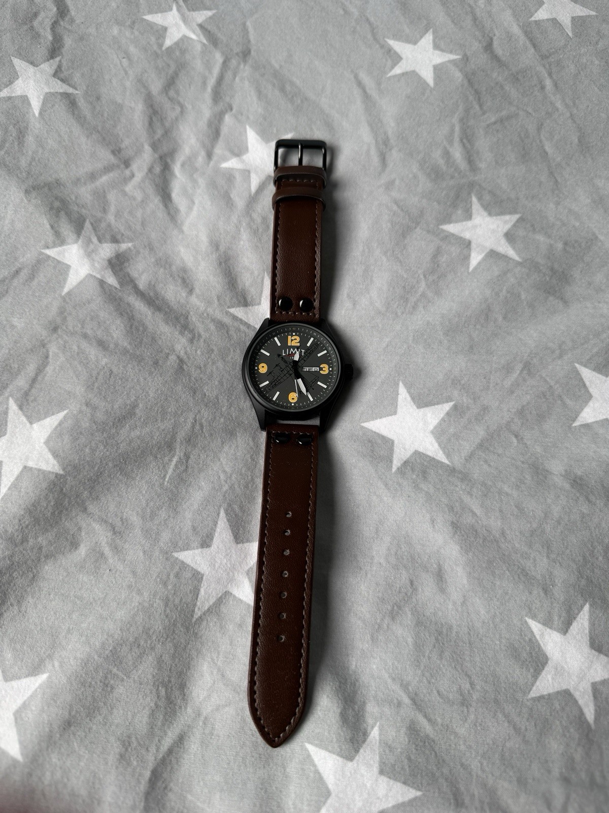 Limit brand timepiece, black dial with yellow numerals and a brown leather strap