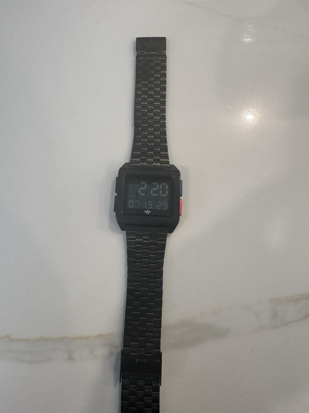 Adidas Archive M1 watch with a matte black finish and a square digital display