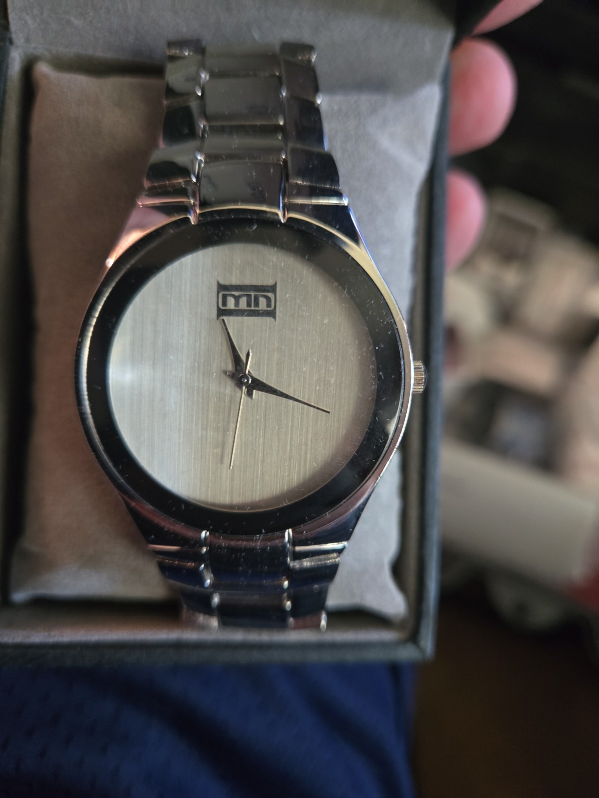 ESQ by Movado watch features a brushed silver dial with a, black-bordered logo
