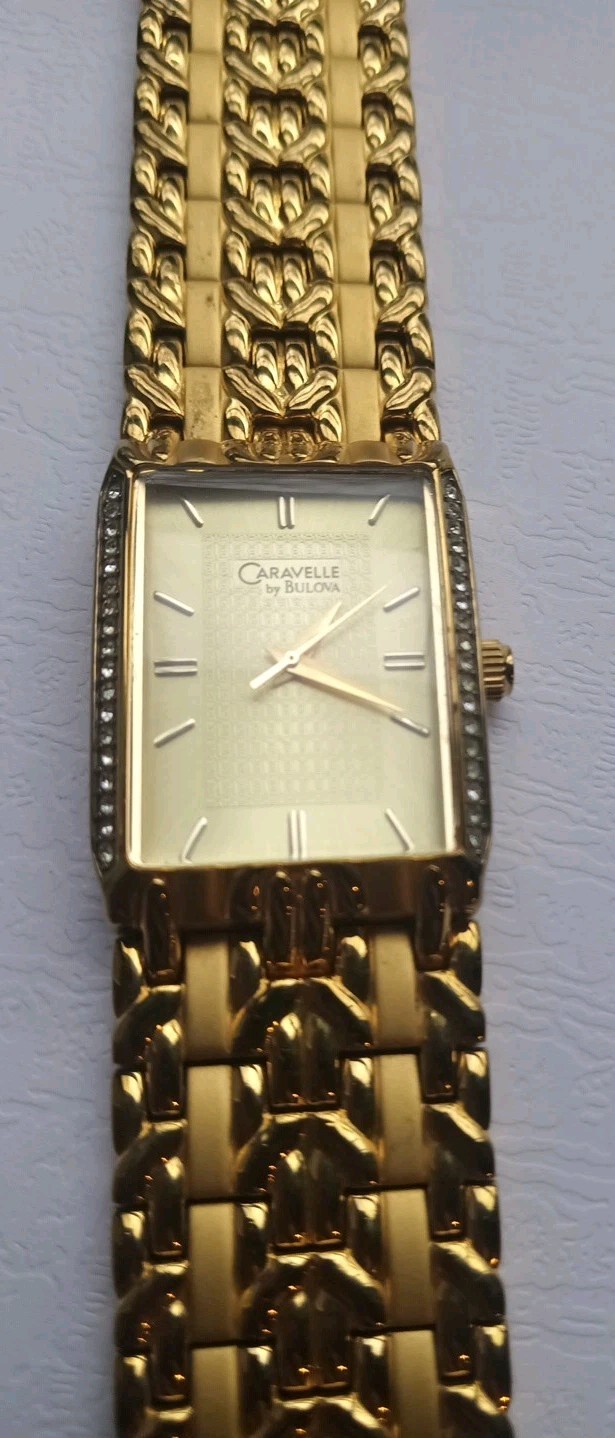 MENS CARAVELLE BY BULOVA GOLD WATCH WITH CRYSTAL DIAMONDS ON EACH SIDE OF FACE