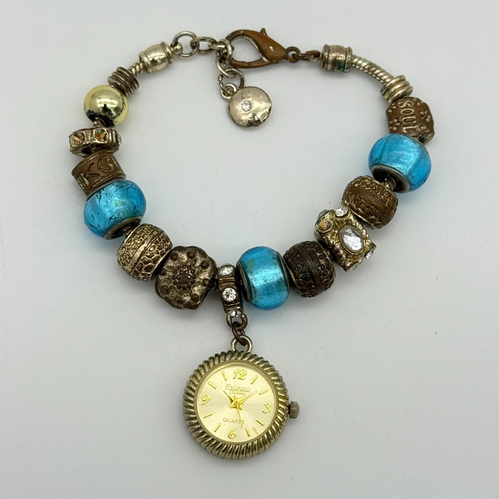 Women’s FIGARO Couture Gold Tone Charm Bracelet 22mm Watch, Blue Accents, Runs