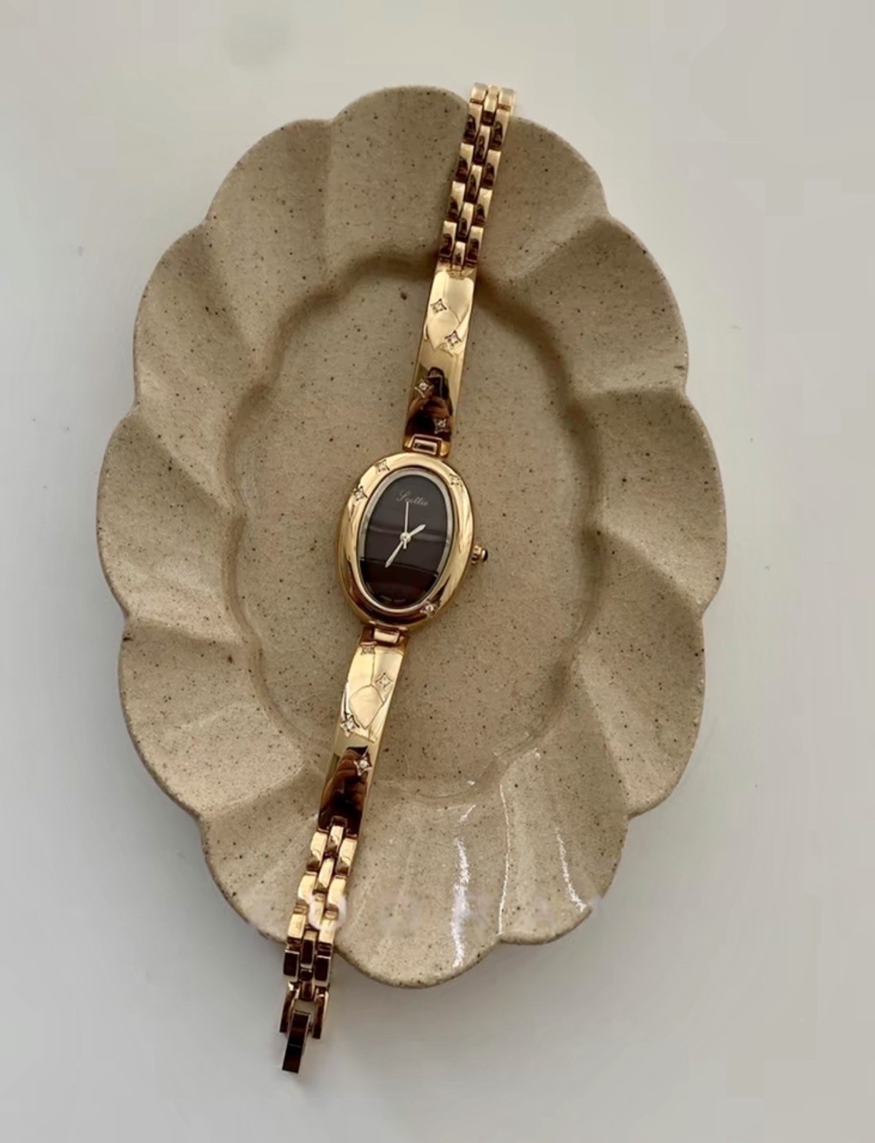 Elegant Gold Oval Ladies Luxury Watch with Dark Brown Maroon Dial & Star Accents