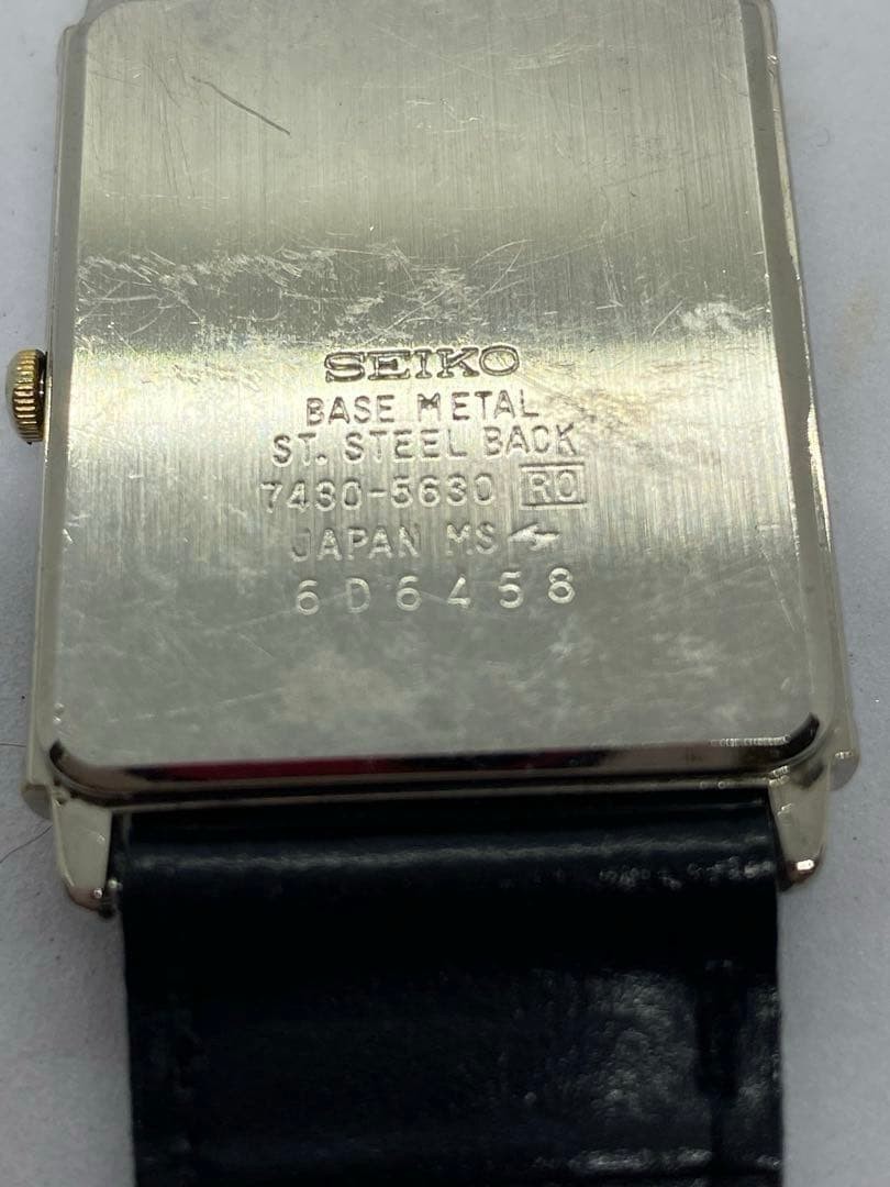 SEIKO rectangular quartz watch with black leather strap.