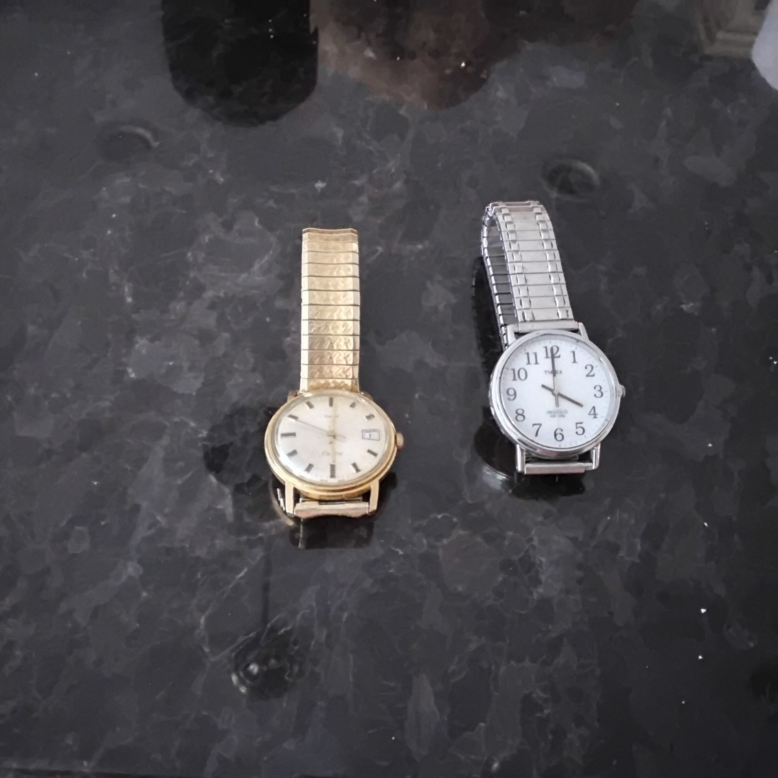 a silver 2016 timex watch and a bronze timex watch