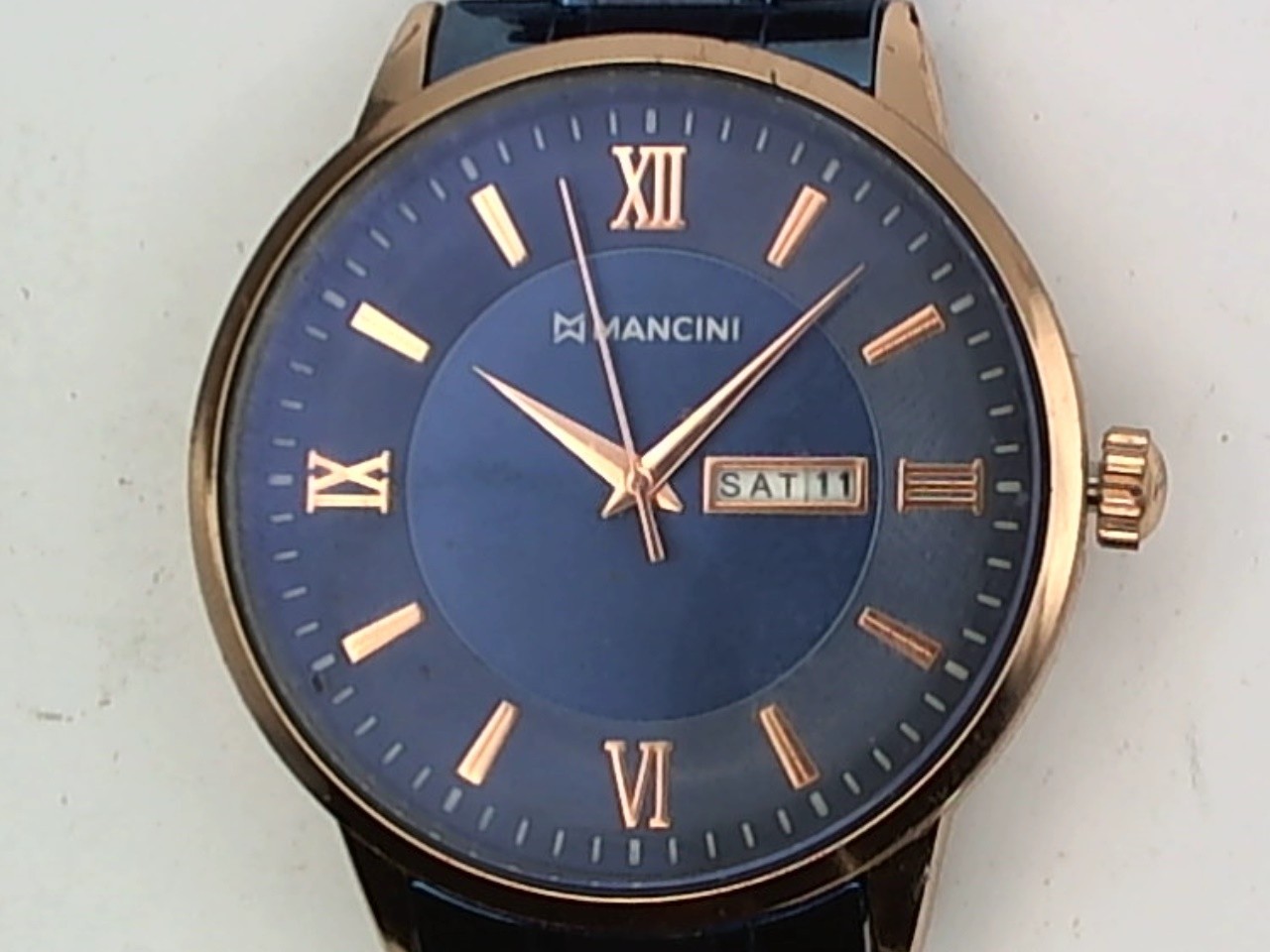 Mancini Day/Date watch with blue dial, gold tone indices and metallic blue case